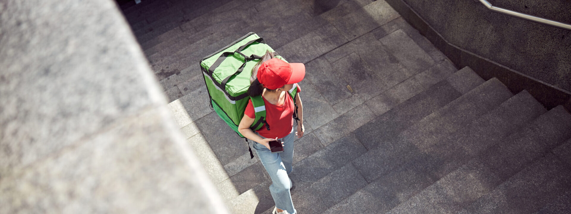 female-food-delivery-worker-walking-up-stairs